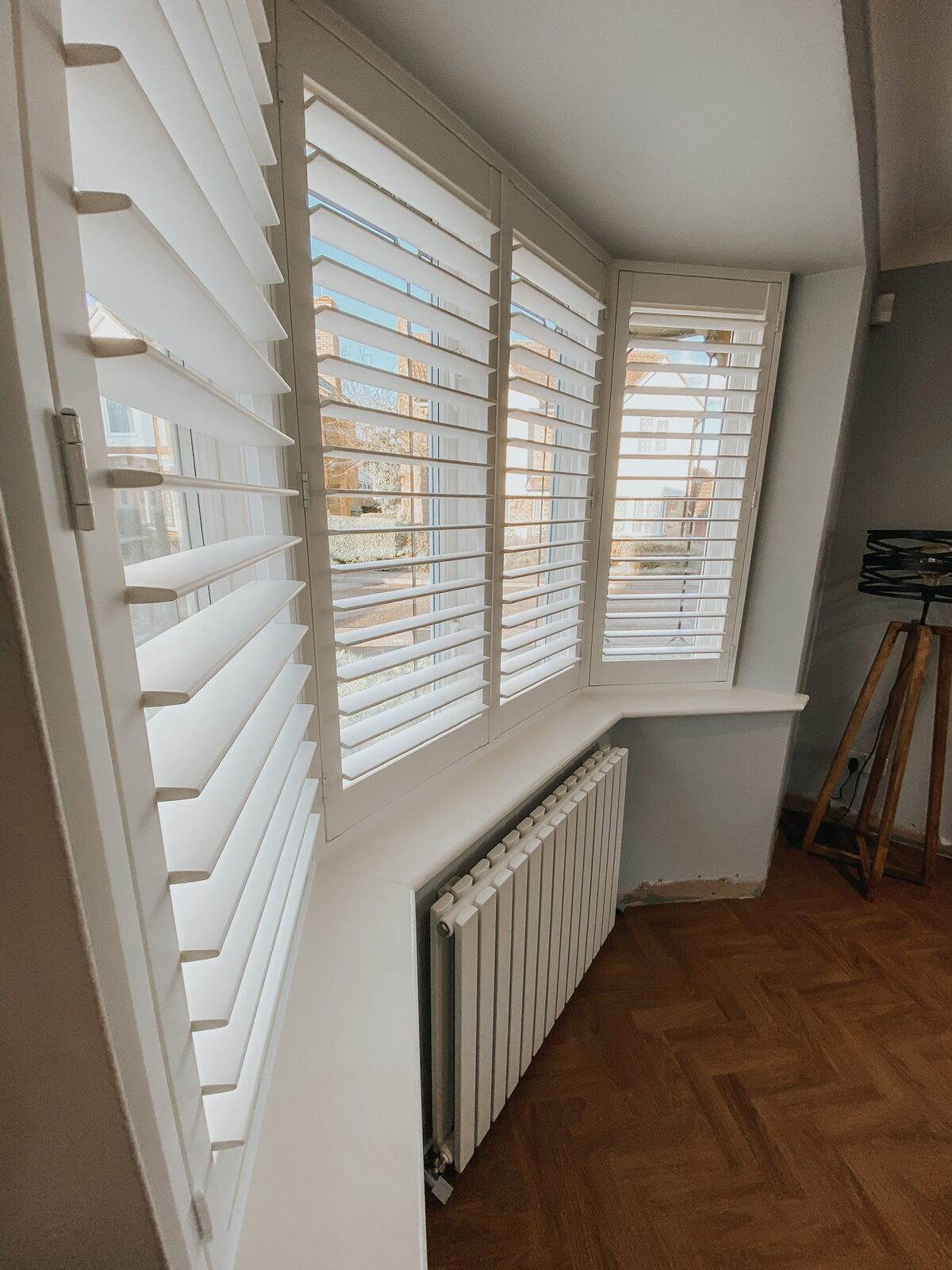 Shutters on a staircase landing window above a radiator