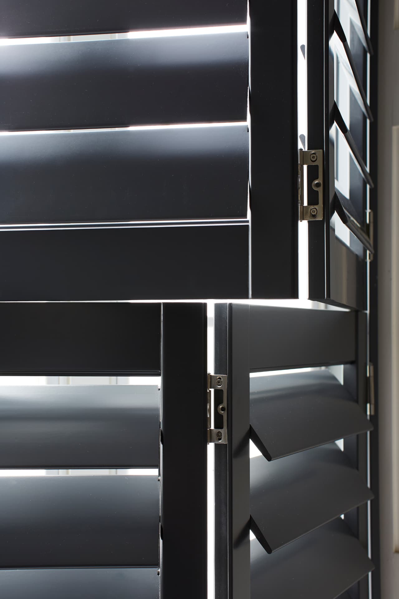 Close-up of black shutter louvres and hinges