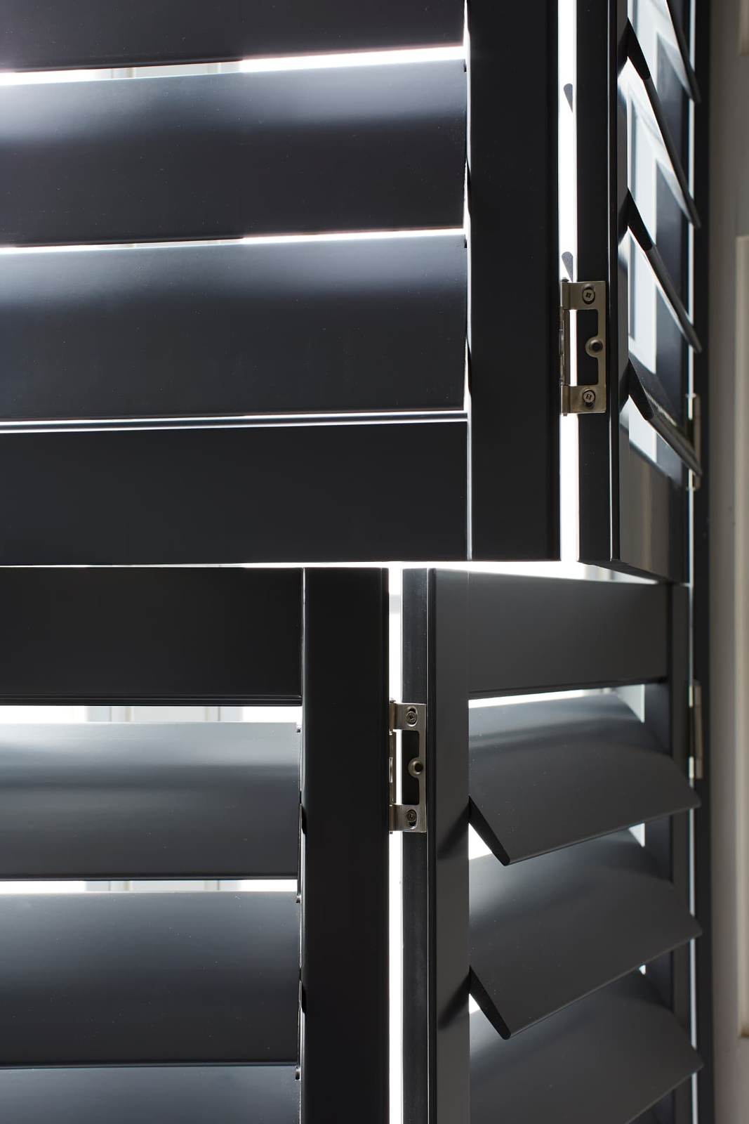 Close-up of black shutter louvres and hinges