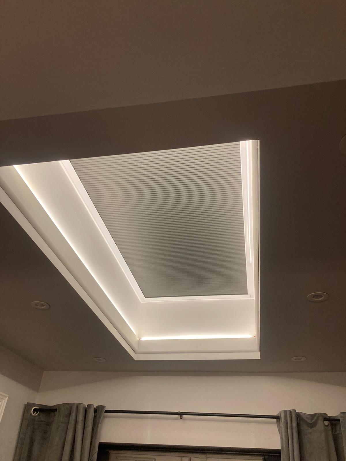 Skylight blind closed in the evening in a bedroom