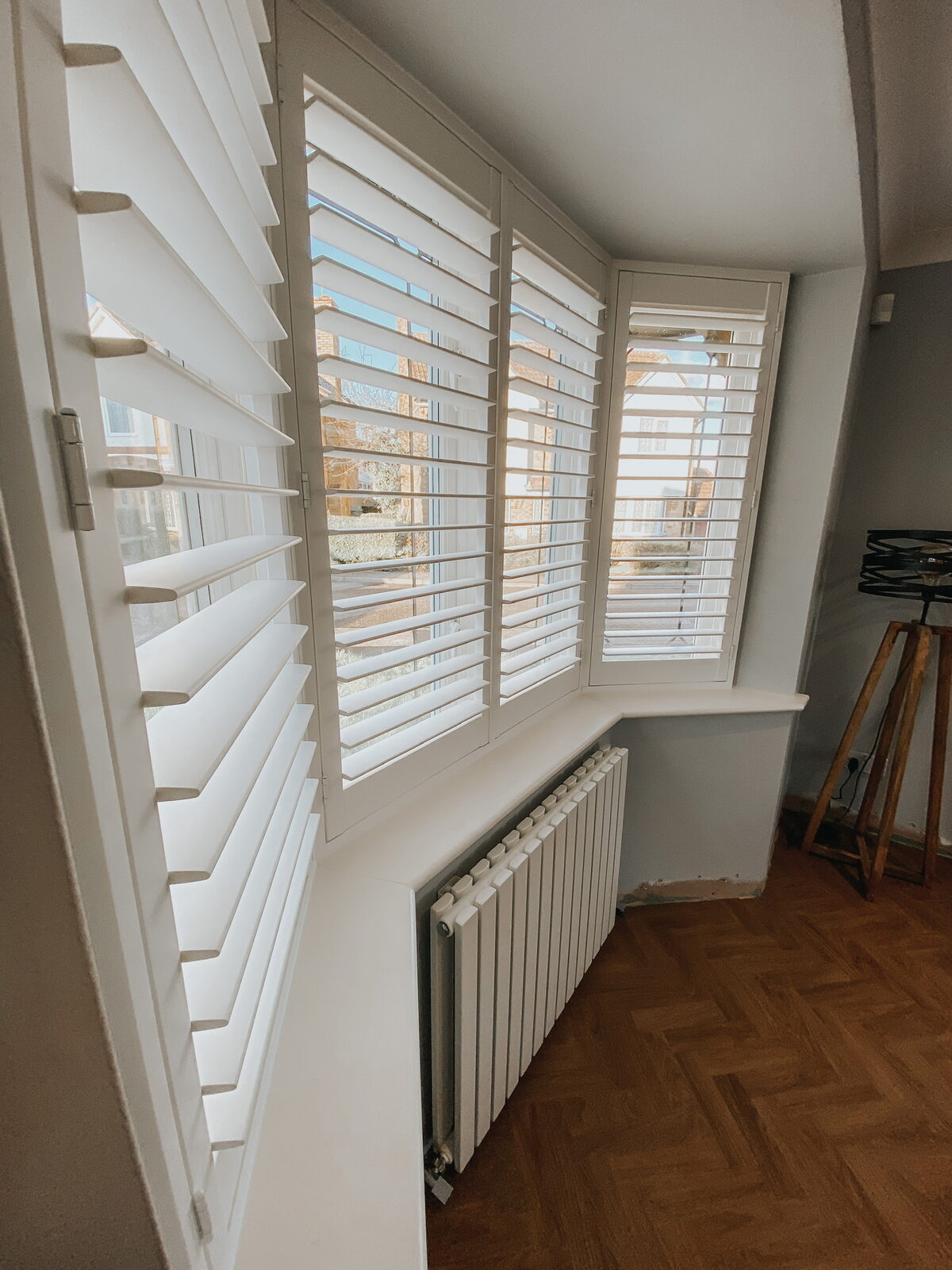Shutters on a staircase landing window above a radiator