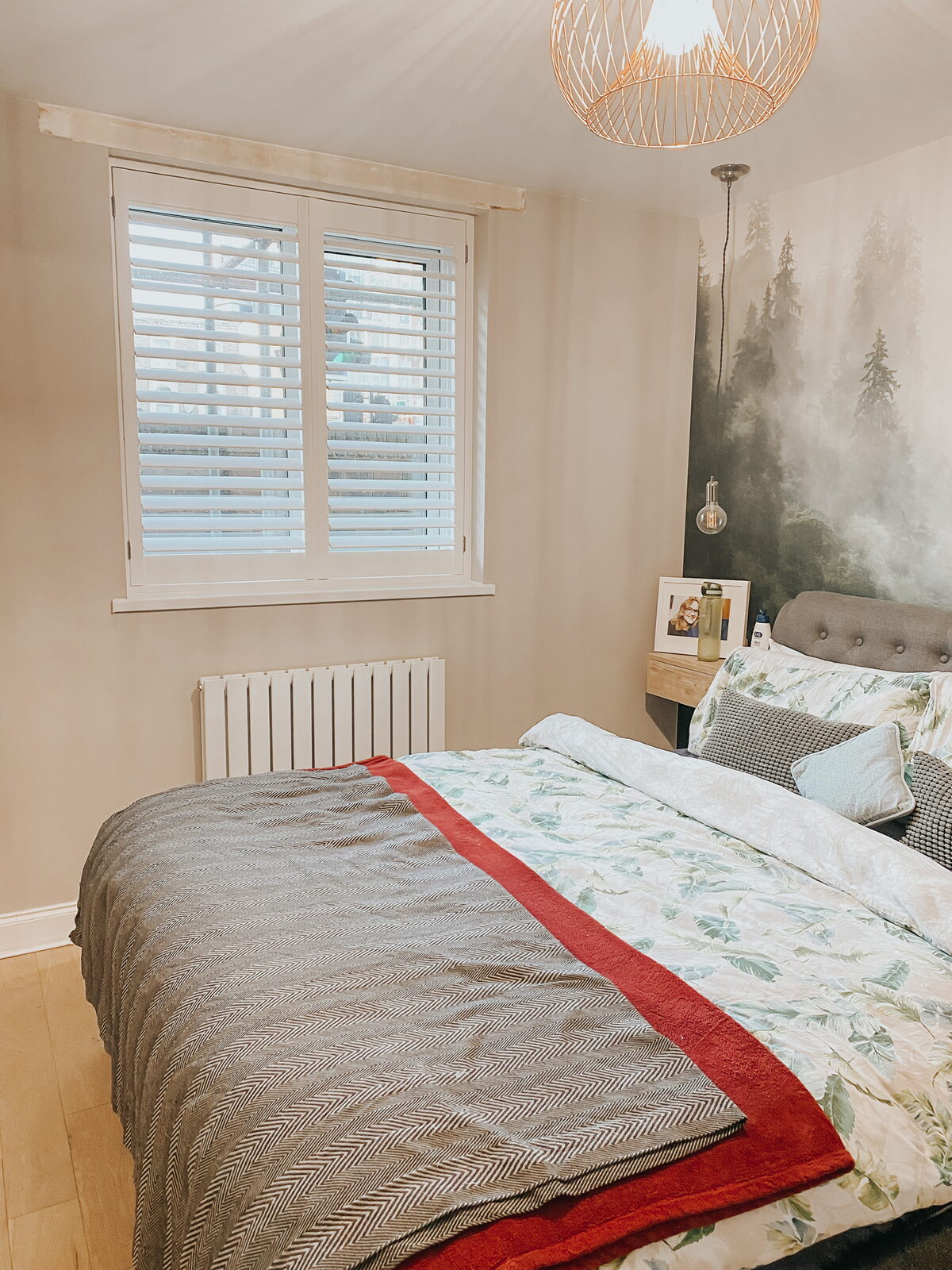 White shutters in a bedroom with a mural wall