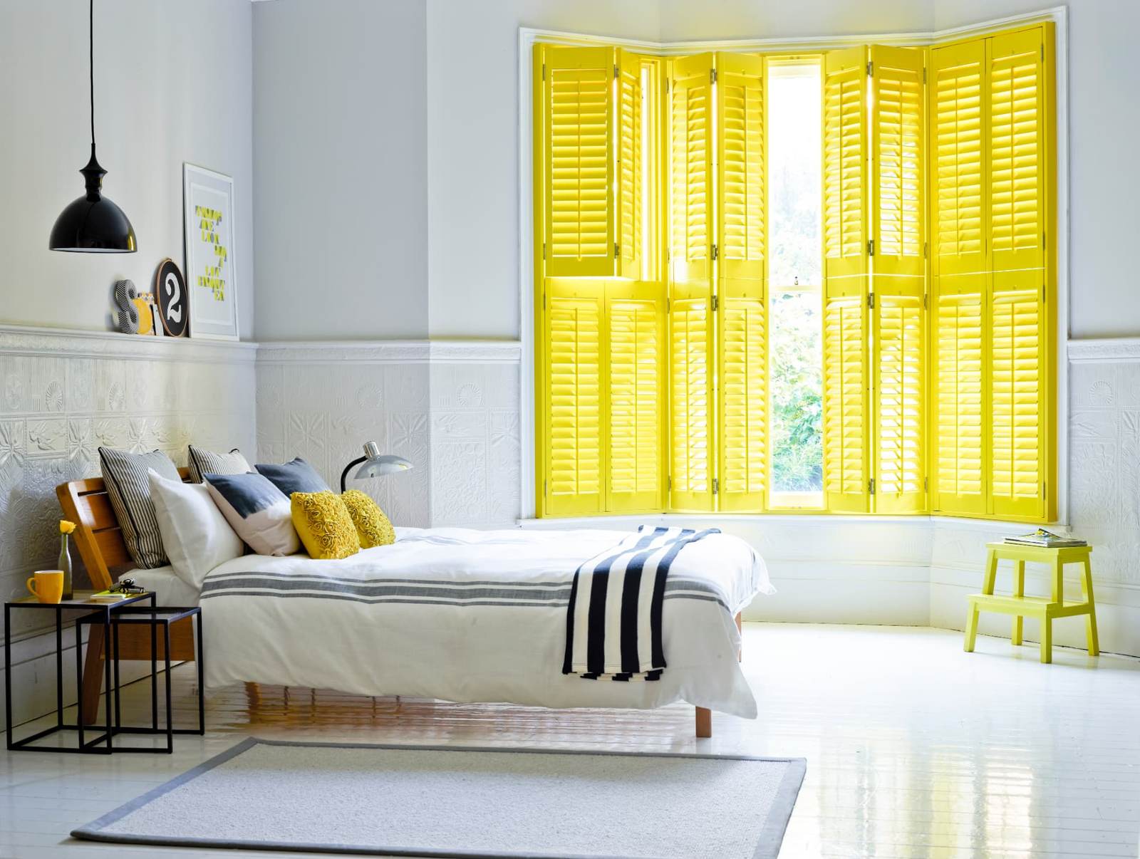 Tier-on-tier shutters in a bay window with the upper tier folded back