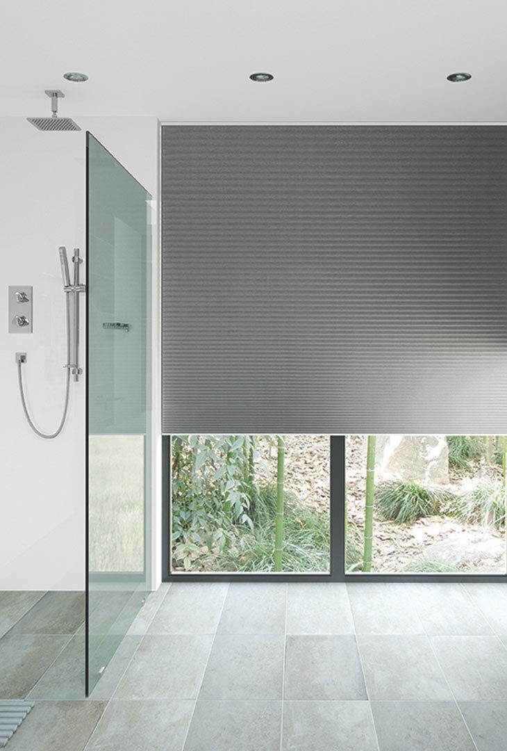 Grey pleated blind in a walk-in shower room