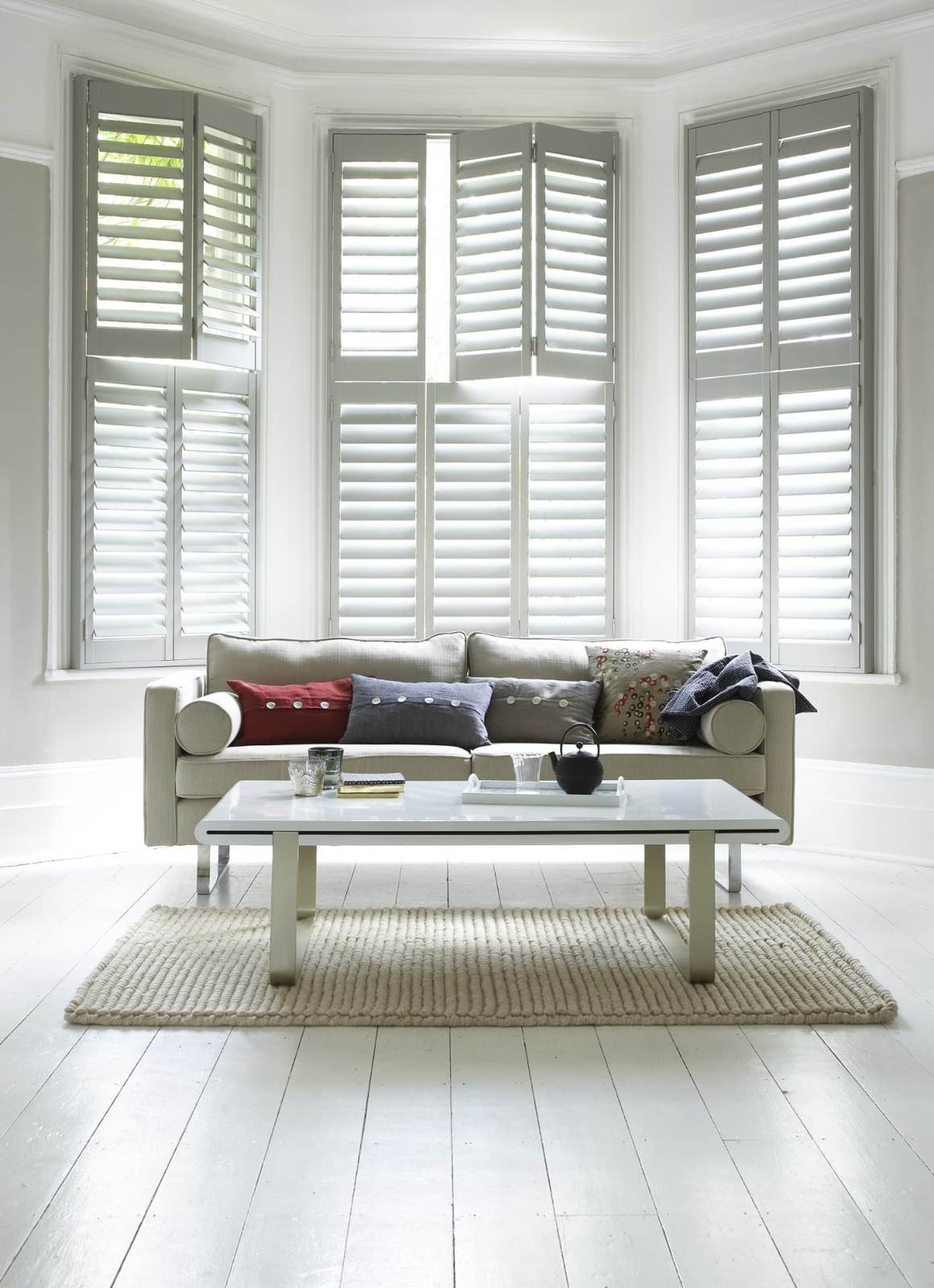 Full height shutters with louvres tilted upward in a street facing living room