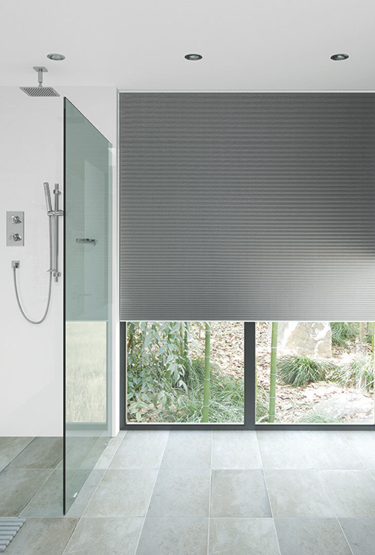 Grey pleated blind in a walk-in shower room
