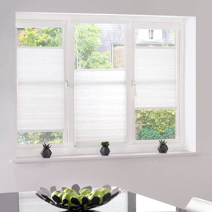 White cellular blinds on a three-pane window with a bottom-up fit